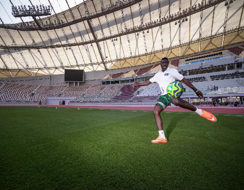 Player strikes football emphatically.